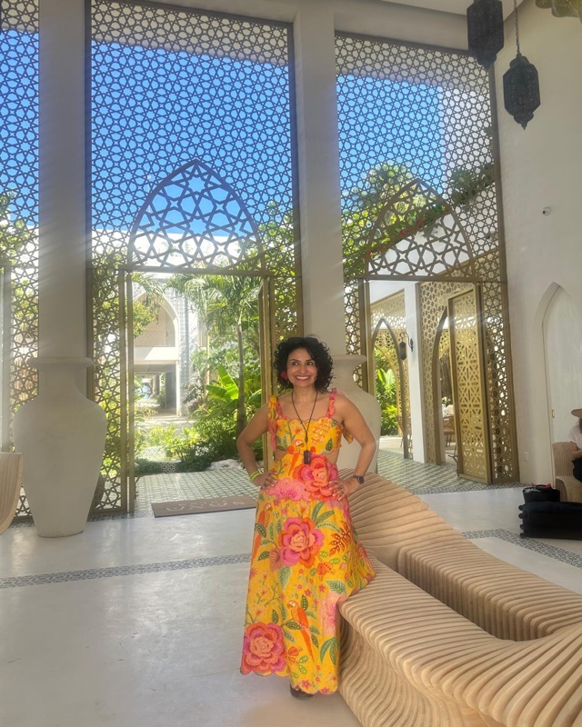 Foto de Claudia Andrade sonriendo en un vestíbulo luminoso